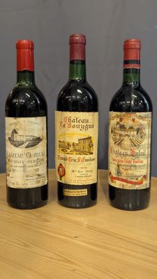 trois bouteilles de vin sont alignées sur une table en bois