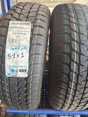 Deux pneus sont empilés sur un présentoir bleu dans un magasin