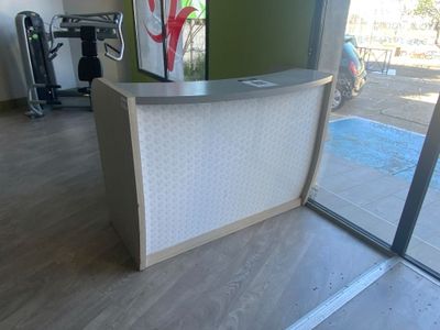 une photo d'un comptoir d'accueil dans une grande salle