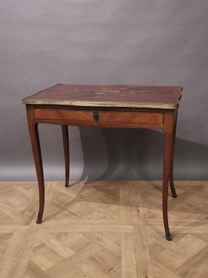 un bureau en bois surmonté d'un tiroir, posé sur un parquet