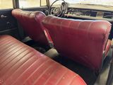 two red leather seats in the back of a car