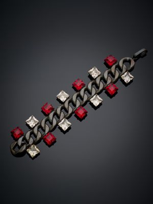 un gros plan d'un bracelet en métal orné de pierres rouges et blanches