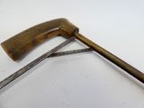 un marteau avec un manche en bois posé sur une surface blanche