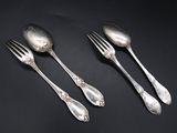 three silver spoons and a fork on a black surface