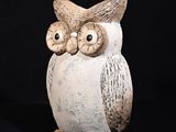 une image représentant une figurine de hibou en céramique sur fond noir