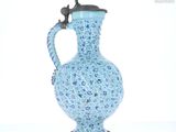 un vase bleu surmonté d'un oiseau