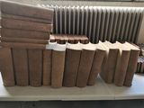 de nombreux livres empilés sur une table devant un radiateur