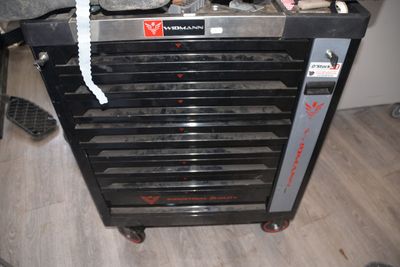 a black tool cabinet with tools in it on a hard wood floor