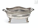 an antique silver plate with handles and handles on a stand