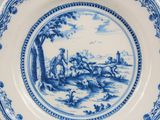 an old blue and white plate with a painting on it