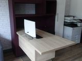 un bureau sur lequel est posé un ordinateur portable dans une pièce