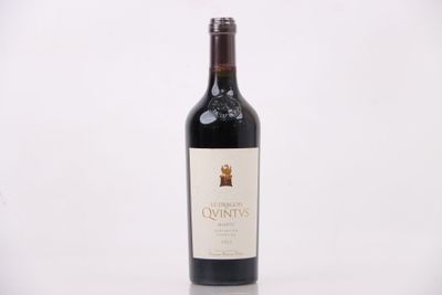 une bouteille de vin rouge posée sur une table blanche