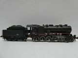 un petit train sur une surface blanche avec un fond gris
