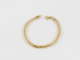 un bracelet en or avec un motif de tresse sur fond blanc