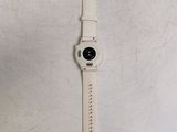 the watch is white and has a black button on it