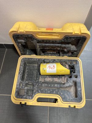 une mallette à outils jaune posée par terre, contenant une bouteille