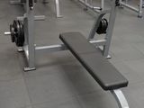 une salle de sport avec un banc et des haltères au milieu de la pièce