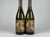 two bottles of wine sitting next to each other on a table