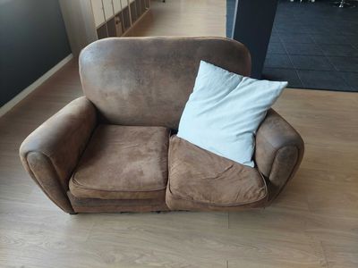 a brown couch with a white pillow on top of it