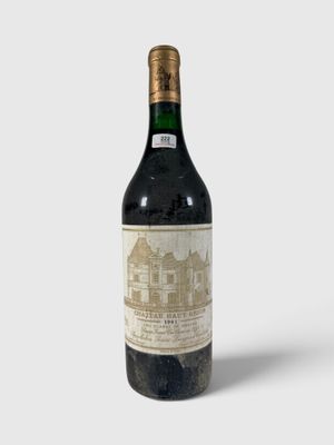 une vieille bouteille de vin posée sur une surface blanche