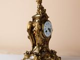 a gold clock sitting on top of a white table