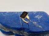 une image représentant une bague avec une pierre noire posée sur une pierre bleue