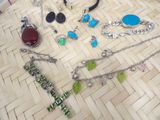 many different necklaces and bracelets laid out on the floor