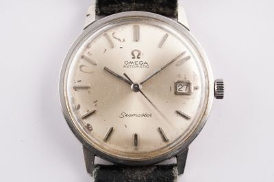 a silver watch on a black strap on a white surface