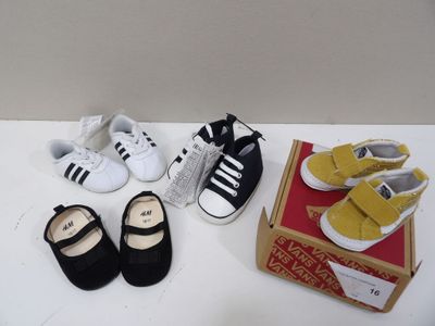 several pairs of baby shoes sitting on a table next to a box of shoes