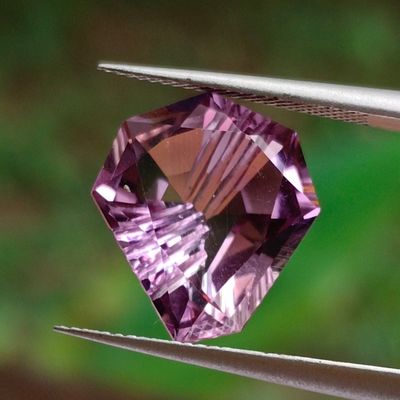 someone is holding a pair of pliers with a purple diamond