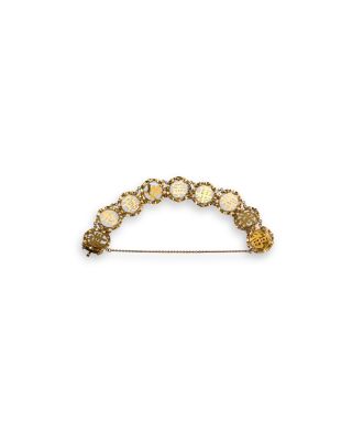 a close up of a gold and white broocher