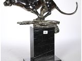 une sculpture en bronze représentant une panthère posée sur un socle en marbre