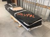 un grand matelas noir posé sur une palette dans une pièce