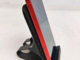 a close up of a cell phone on a stand on a table