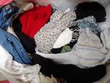 a pile of clothes in a laundry basket on the floor