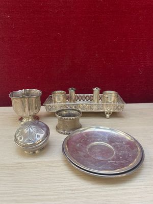 a silver plate and silver cups on a wooden table