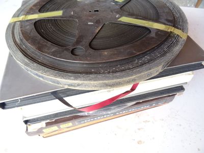 une bobine de film posée sur une pile de livres
