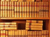 de nombreux livres anciens posés sur une étagère en bois dans la pièce