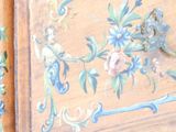 a close up of a painting on a wooden cabinet