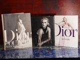 Trois livres sont posés sur une table dont le sol est recouvert de carreaux bleus.