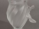 a glass vase with a flower on it on a table