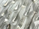 a lot of silver spoons and forks in a plastic bag