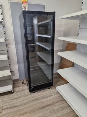 un réfrigérateur vide au milieu d'un magasin