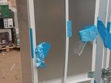 an image of a refrigerator in a warehouse with blue tape on the doors