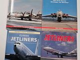 three books of jetliners and jetliners sitting on a table