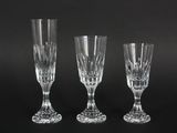 three crystal wine glasses sitting on top of a black table