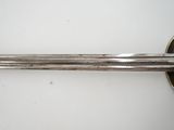 a close up of a sword on a white surface with a white background