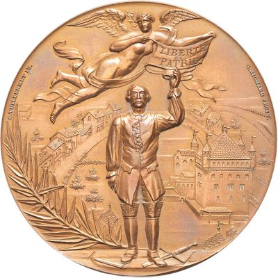 a gold medal with a statue of a man holding a bird