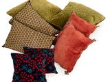 plusieurs coussins de différentes couleurs posés sur une surface blanche, avec un fond blanc