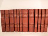 six vieux livres alignés sur une surface blanche